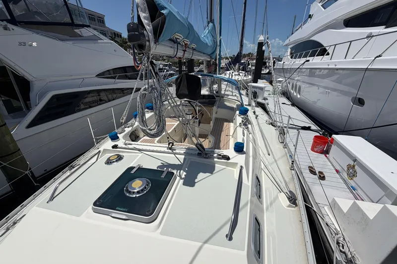 Slide: The Image of 1987 Moody 376 sailboat docked among luxury yachts on a sunny day. - 11