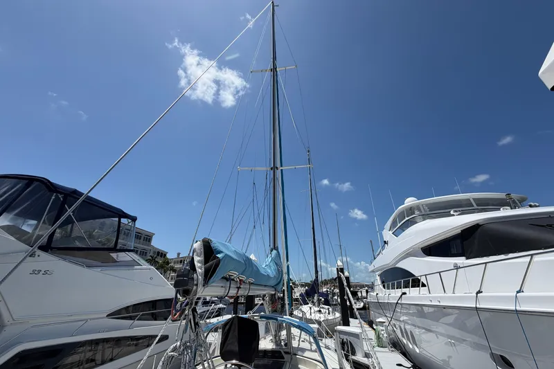 Slide: The Image of Sailboats docked at marina under clear blue sky, featuring 1987 Moody 376 yacht. - 17