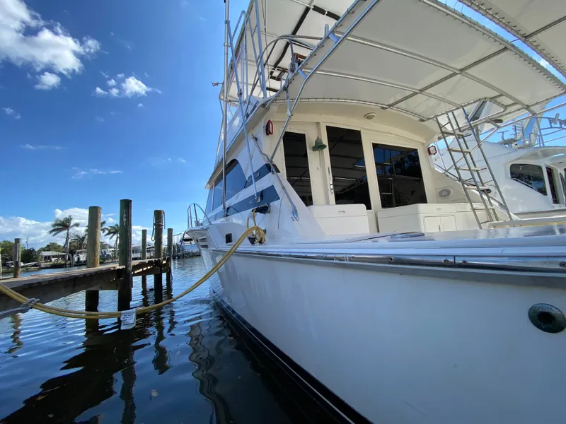 Slide: The Image of 1982 Bertram 46.6 War Wagon yacht docked, showcasing sleek design under a clear blue sky. - 11