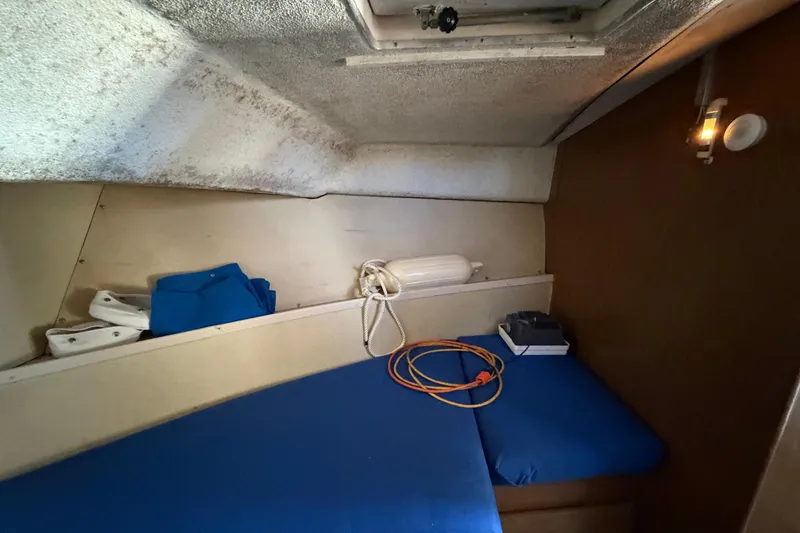 Slide: The Image of 1973 Chris-Craft 30 Tournament FB cabin interior with blue cushions and nautical equipment. - 18