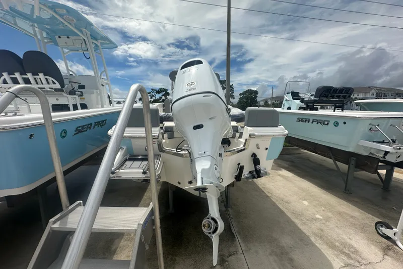 Slide: The Image of 2027 Pioneer 180 Islander boat with outboard motor, displayed outdoors. - 3