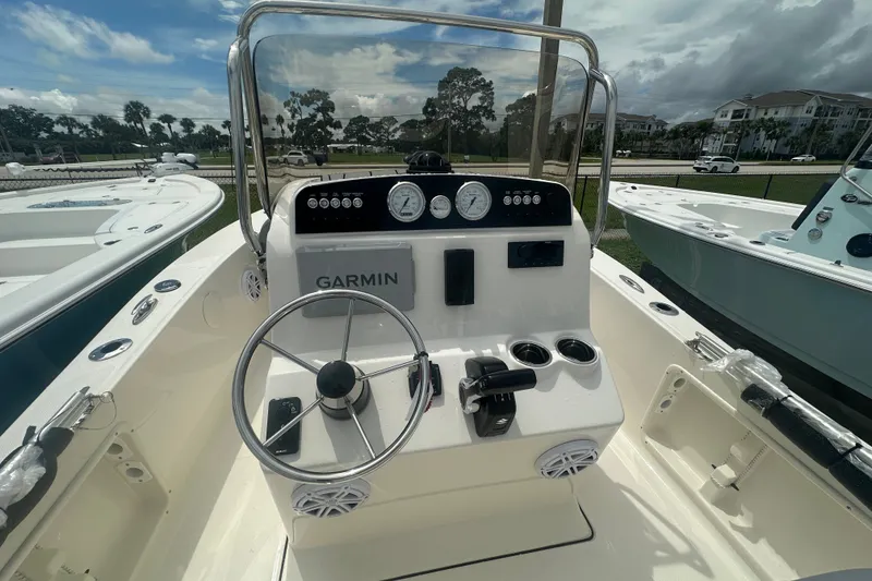 Slide: The Image of 2027 Pioneer 180 Islander boat dashboard with Garmin navigation system under a partly cloudy sky. - 4