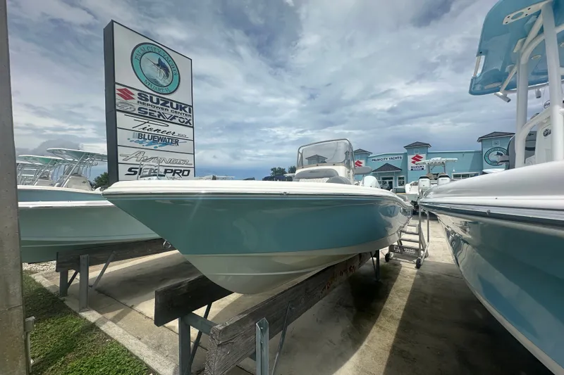 Slide: The Image of 2027 Pioneer 180 Islander boat displayed at dealership with clear sky background. - 1