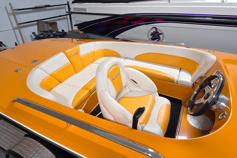 Slide: The Image of Orange and white interior of a 2012 Hornet Marine 17 boat, featuring sleek seating and steering wheel. - 3