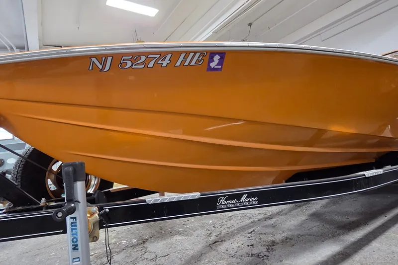 Slide: The Image of 2012 Hornet Marine 17 boat in orange, displayed on a trailer with registration NJ 5274 HB. - 30