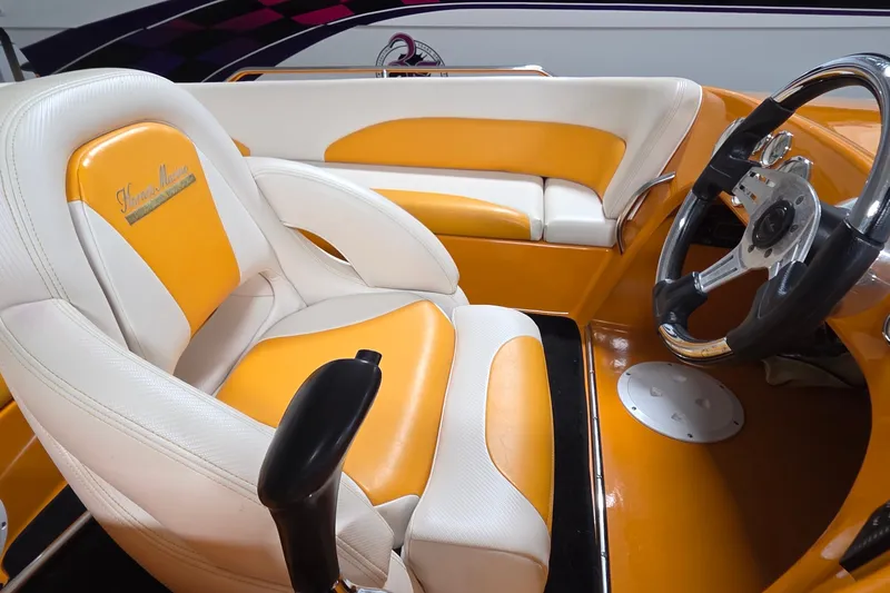 Slide: The Image of 2012 Hornet Marine 17 boat interior with orange and white seating and steering wheel. - 25