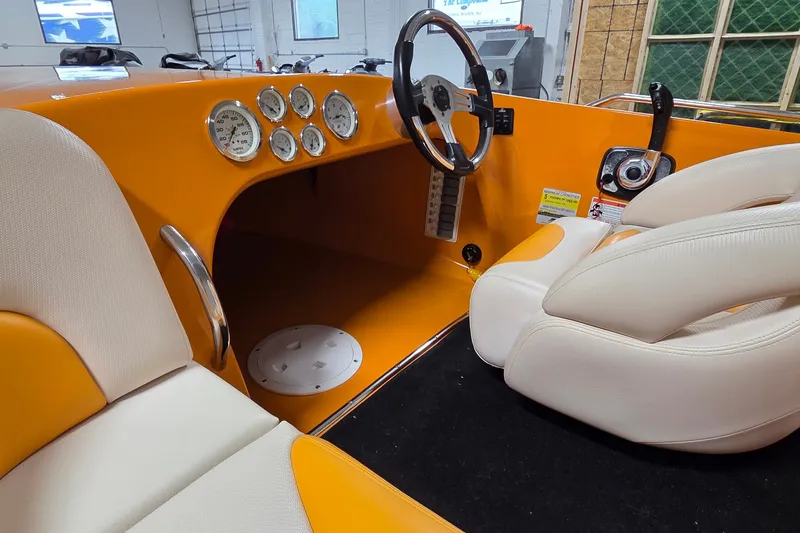 Slide: The Image of 2012 Hornet Marine 17 boat interior with orange dashboard and white seating. - 14