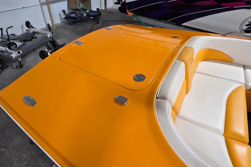 Slide: The Image of 2012 Hornet Marine 17 boat with vibrant orange and white seating in a garage setting. - 5