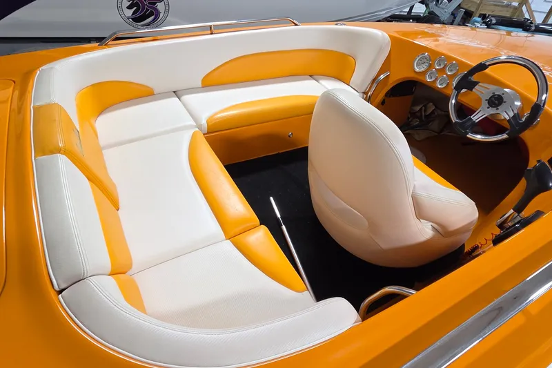 Slide: The Image of Orange and white interior of a 2012 Hornet Marine 17 boat, featuring sleek seating and dashboard. - 4