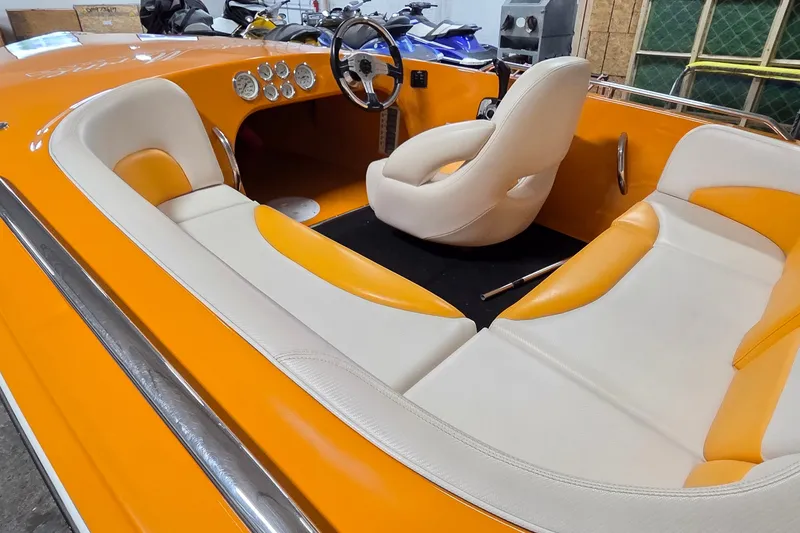 Slide: The Image of 2012 Hornet Marine 17 boat interior with orange and white seating, steering wheel, and dashboard. - 13