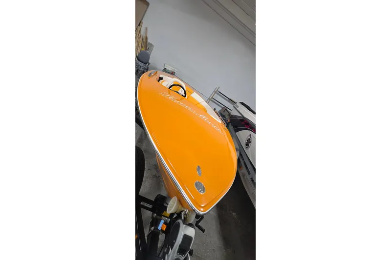 Slide: The Image of Orange 2012 Hornet Marine 17 boat in storage, showcasing sleek design and vibrant color. - 8