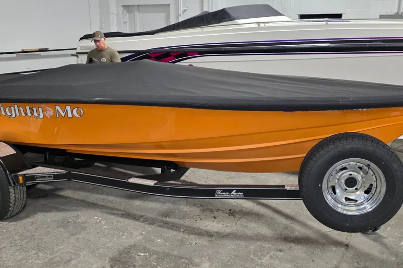 The Image of Orange 2012 Hornet Marine 17 boat with cover on trailer, labeled "Mighty Mo." - 1