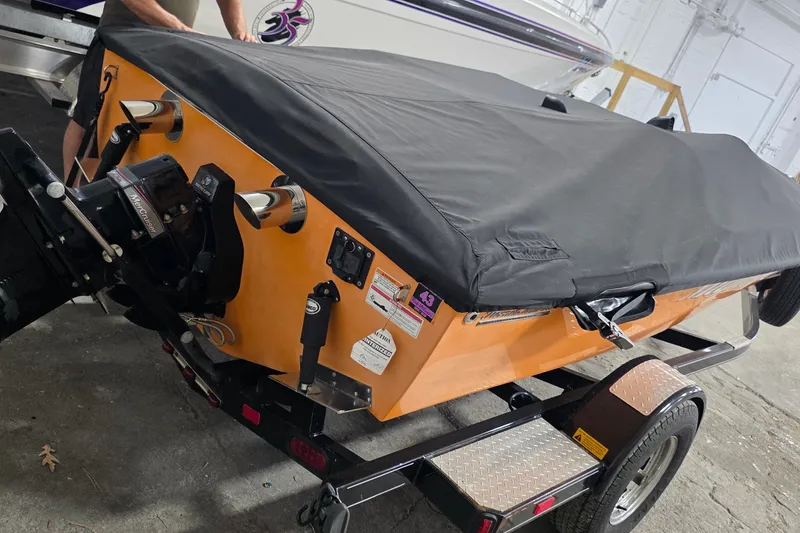 Slide: The Image of 2012 Hornet Marine 17 boat with black cover on trailer in garage. - 6