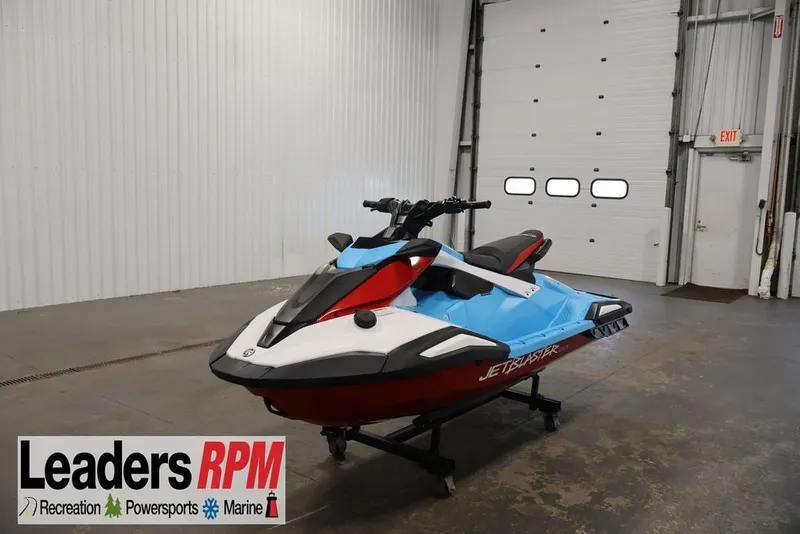 The Image of 2027 Yamaha WaveRunner JetBlaster DLX 3-Up in showroom, vibrant blue and red design. - 2