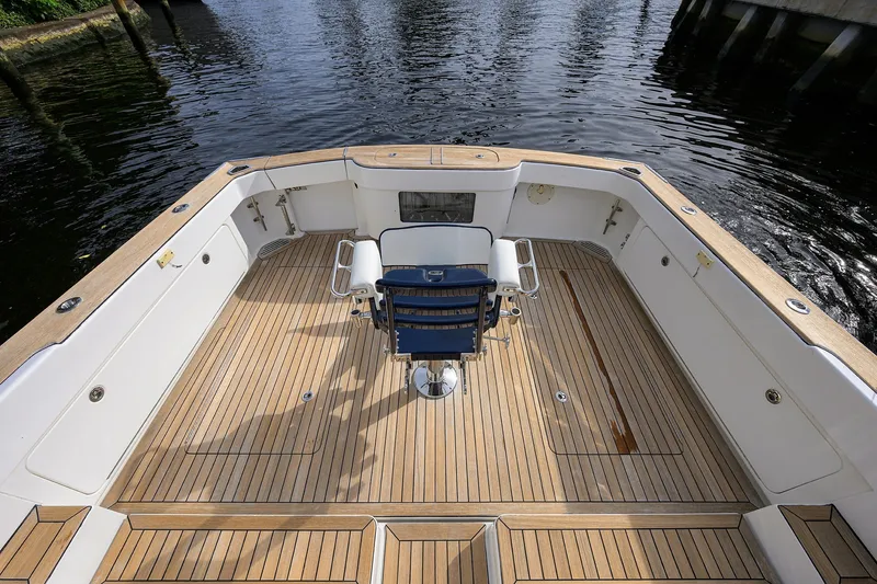 Slide: The Image of 2018 Bertram 35 Flybridge boat deck with wooden flooring and central chair. - 12