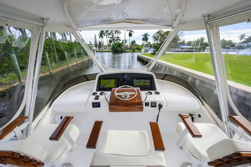 Slide: The Image of 2018 Bertram 35 Flybridge helm with modern navigation equipment and scenic waterway view. - 24