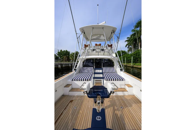 Slide: The Image of 2018 Bertram 35 Flybridge yacht with striped seating and wooden deck. - 16