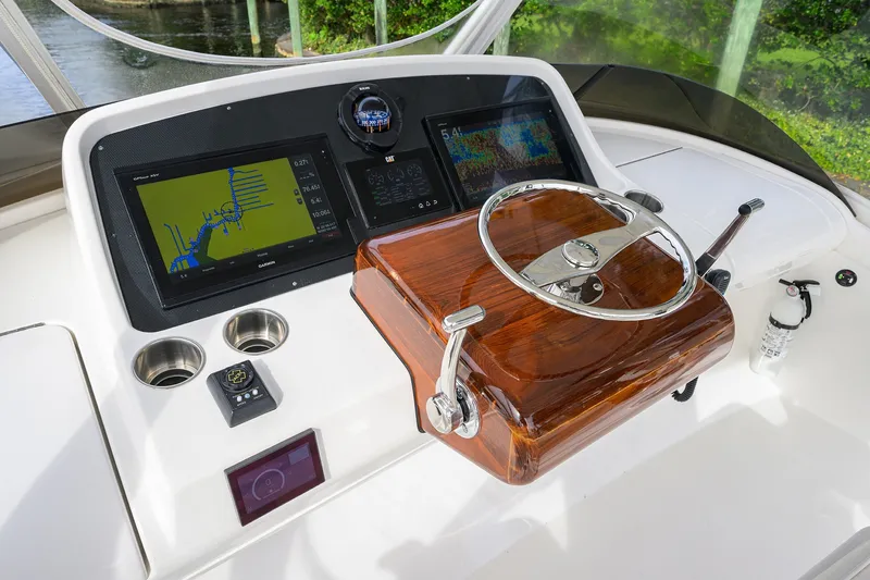 Slide: The Image of 2018 Bertram 35 Flybridge helm with navigation screens and polished wood steering wheel. - 29