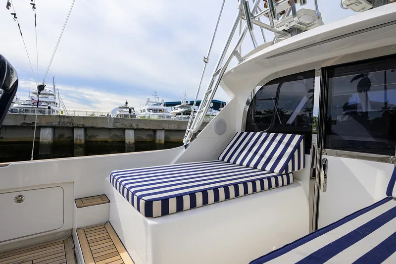 Slide: The Image of 2018 Bertram 35 Flybridge yacht with striped cushions docked at marina. - 22