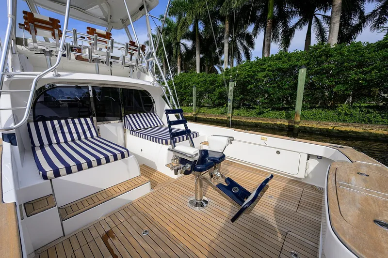 Slide: The Image of 2018 Bertram 35 Flybridge yacht with striped seating and fishing chair on deck. - 17