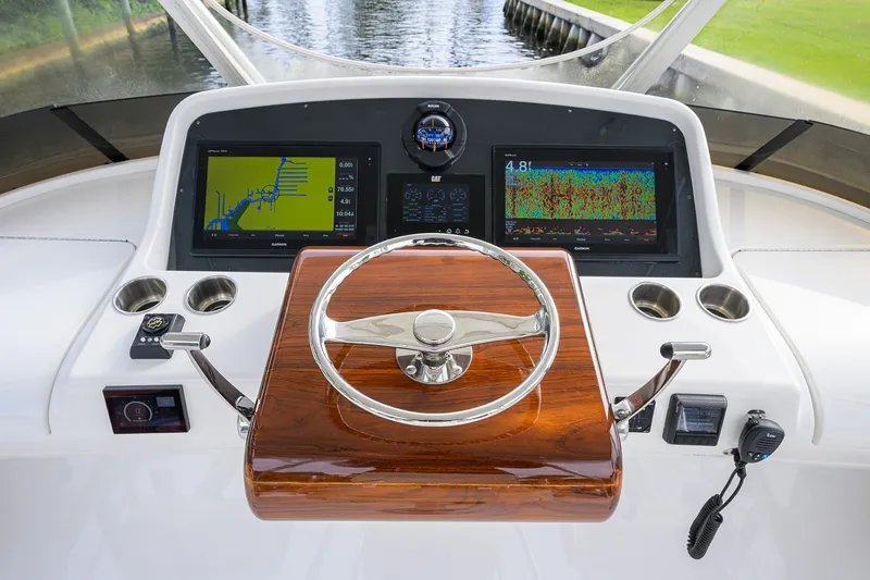 Slide: The Image of 2018 Bertram 35 Flybridge helm with navigation screens and wooden steering wheel. - 28