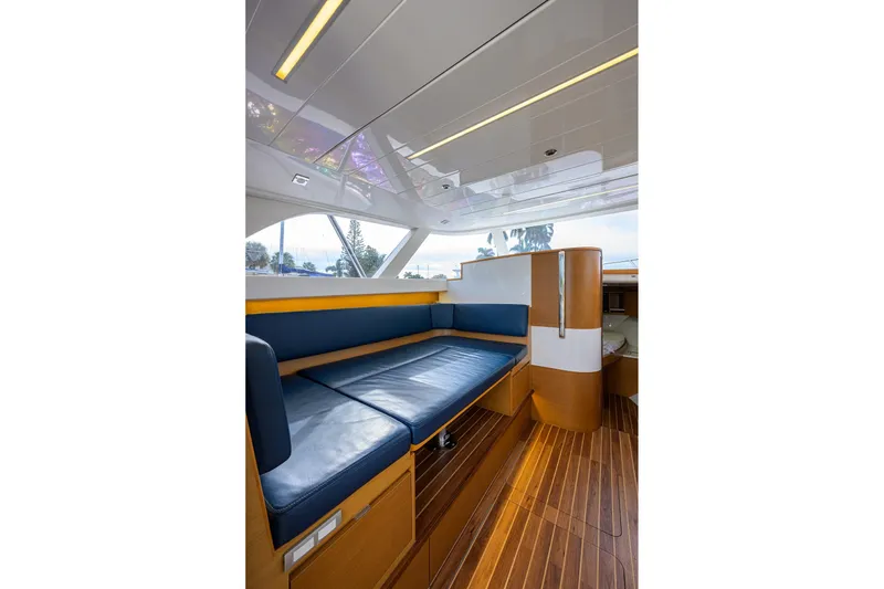 Slide: The Image of Interior of 2018 Bertram 35 Flybridge with blue seating and wooden flooring. - 36