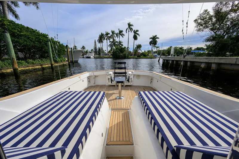 Slide: The Image of 2018 Bertram 35 Flybridge boat with striped seating, docked in a scenic marina. - 19