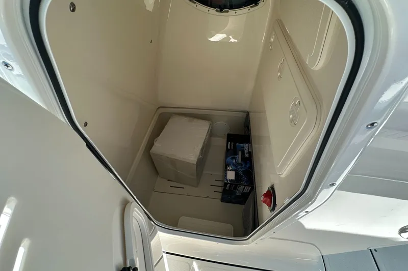 Slide: The Image of Storage compartment of 2027 Pioneer 222 Sportfish boat, featuring a box and marine supplies. - 9