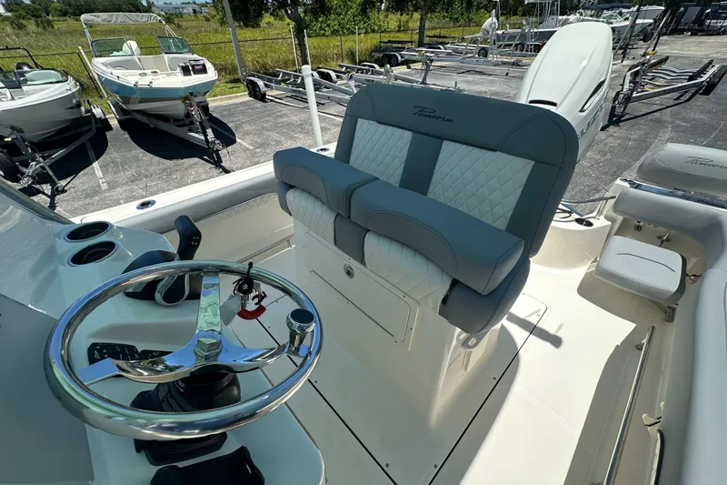 Slide: The Image of 2027 Pioneer 222 Sportfish boat interior with steering wheel and cushioned seating. - 10