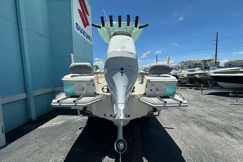 Slide: The Image of 2027 Pioneer 222 Sportfish boat with Suzuki engine, parked outdoors under clear blue sky. - 3