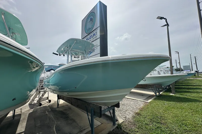 Slide: The Image of 2027 Pioneer 222 Sportfish boat displayed outdoors at a dealership. - 1