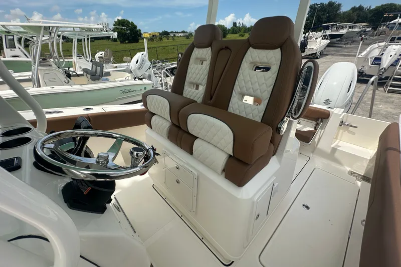 Slide: The Image of Luxurious seating and steering wheel of 2027 Pioneer 270 Pelagic boat in a marina setting. - 9