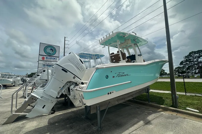Slide: The Image of 2027 Pioneer 270 Pelagic boat with Suzuki outboard motor displayed outdoors. - 2