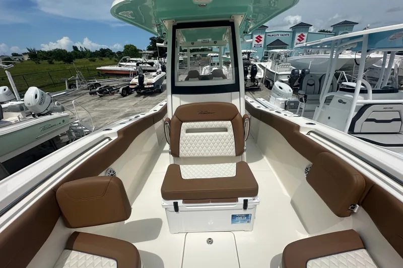 Slide: The Image of 2027 Pioneer 270 Pelagic boat interior with brown and white seating, docked at a marina. - 7
