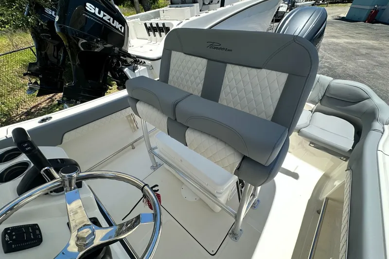 Slide: The Image of 2027 Pioneer 202 Islander boat interior with steering wheel and seating, featuring Suzuki engine. - 9