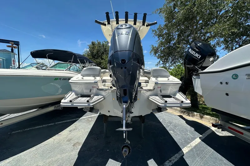 Slide: The Image of 2027 Pioneer 202 Islander boat with powerful outboard motor, parked outdoors. - 4