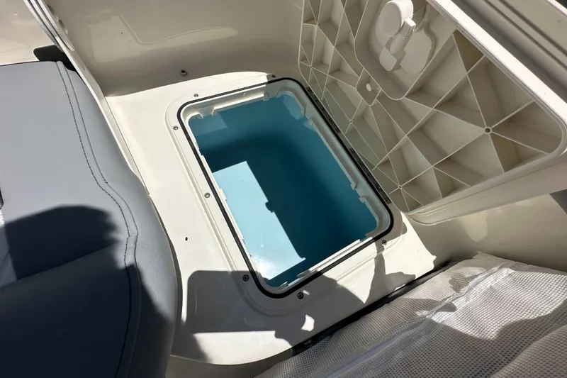 Slide: The Image of Open storage compartment on 2027 Pioneer 202 Islander boat, featuring a blue interior. - 11