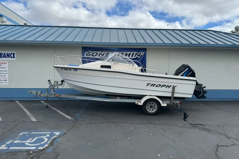 The Image of 2003 Trophy 1802 Walkaround boat on trailer, parked outside a building. - 1