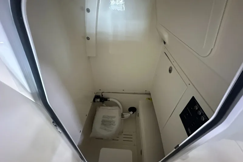 Slide: The Image of Interior view of 2026 Pioneer 250 Pelagic boat compartment, featuring storage and control panel. - 12