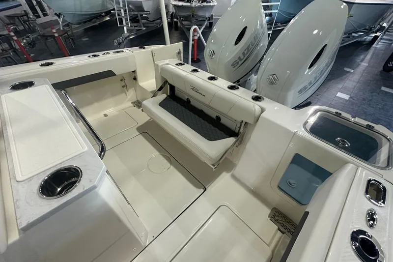 Slide: The Image of 2026 Pioneer 250 Pelagic boat interior with seating and Suzuki engines in showroom. - 14