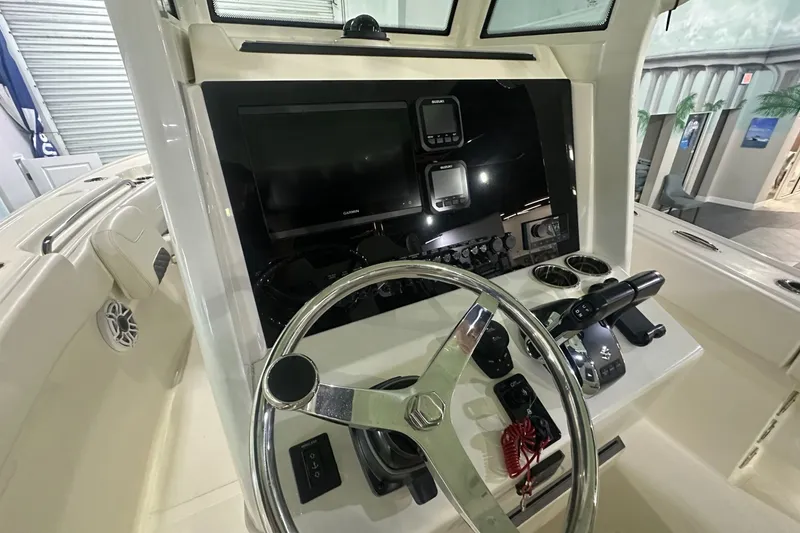 Slide: The Image of 2026 Pioneer 250 Pelagic boat dashboard with steering wheel and navigation controls. - 5