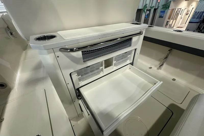 Slide: The Image of 2026 Pioneer 250 Pelagic boat interior with open storage compartment and cup holders. - 15