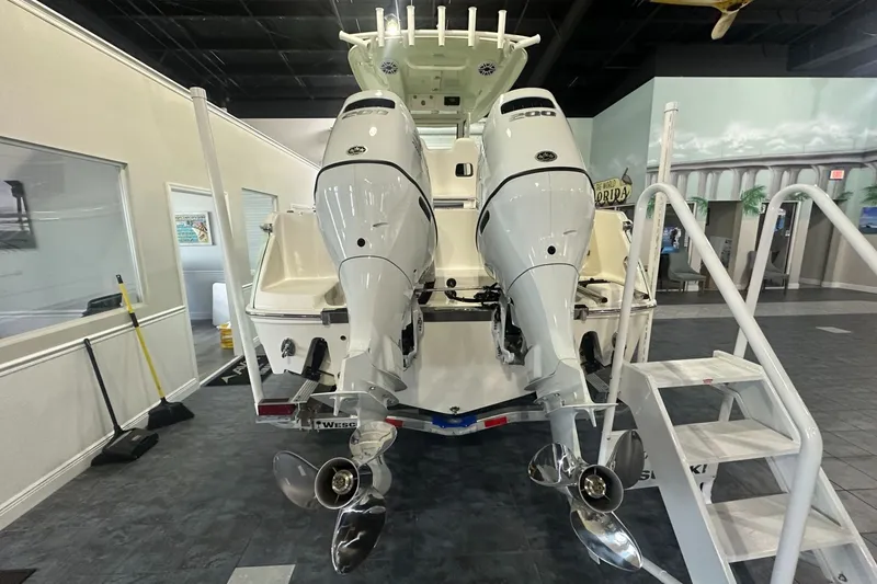 Slide: The Image of 2026 Pioneer 250 Pelagic boat with dual outboard engines displayed indoors. - 3