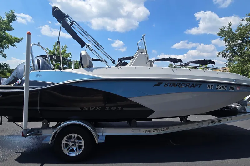 Slide: The Image of 2025 Starcraft SVX 191 OB CC boat on trailer under blue sky. - 2
