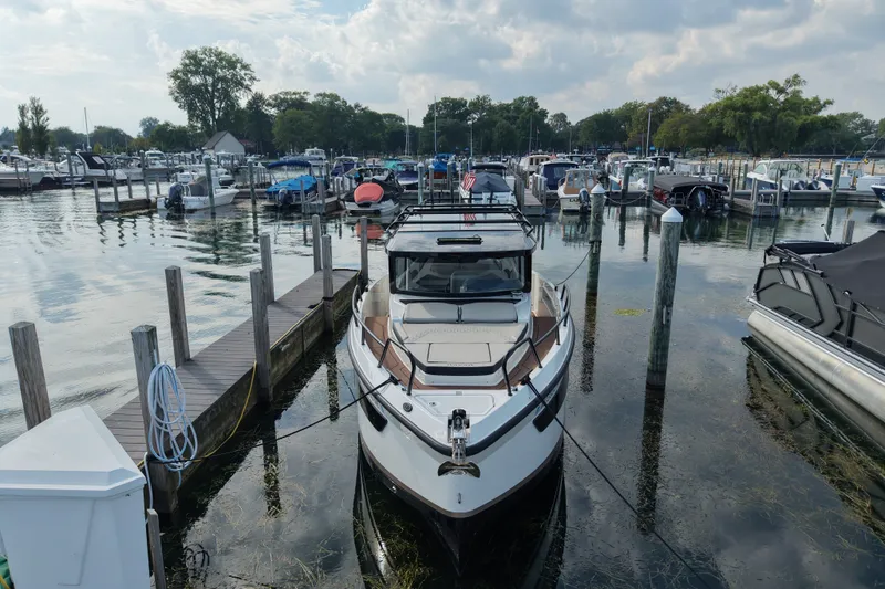 Slide: The Image of A 2025 Navan C30 boat docked at a marina with surrounding vessels. - 18
