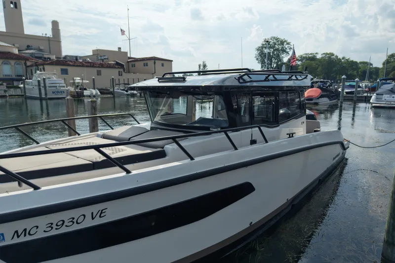 Slide: The Image of 2025 Navan C30 boat docked at a marina with buildings and boats in the background. - 27