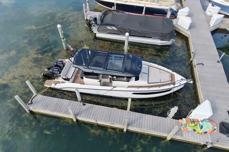Slide: The Image of 2025 Navan C30 boat docked at marina, aerial view, surrounded by clear water and seaweed. - 25