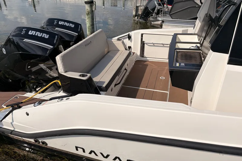 Slide: The Image of 2025 Navan C30 boat interior with seating, dual Mercury outboards, and a compact kitchenette. - 14
