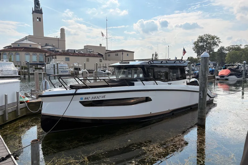 The Image of 2025 Navan C30 boat docked at a marina with historic buildings in the background. - 0