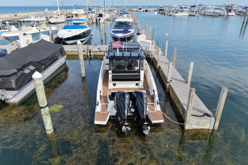 Slide: The Image of 2025 Navan C30 boat docked at a marina, surrounded by other vessels. - 20